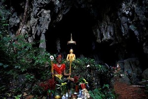 Bức tượng Phật phía trước một hang động gần hang Tham Luang là nơi nhiều người tìm đến cầu nguyện cho đội bóng nhí và huấn luyện viên gặp nạn. Ảnh:Soe Zeya Tun/Reuters.
