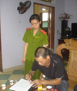 Nguyễn Xuân Hùng đang kí vào biên bản khám xét nơi ở.