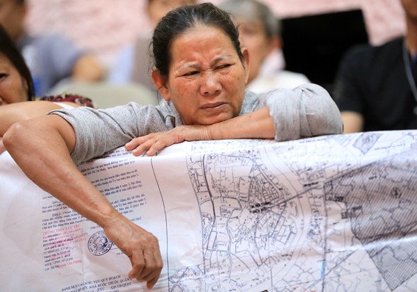 Người dân Thủ Thiêm mang bản đồ quy hoạch đến buổi làm việc. Ảnh: Hữu Khoa.