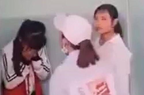 Nữ sinh lớp 7 (trái) bị vây đánh trong nhà vệ sinh ở Phú Yên, hôm 15/3. Ảnh: Cắt từ video