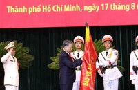 Tổng Bí thư, Chủ tịch nước Tô Lâm gắn Huy hiệu Anh hùng lực lượng vũ trang nhân dân lên lá cờ truyền thống của Công an Thành phố Hồ Chí Minh. Ảnh Hoàng Thịnh