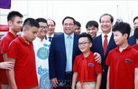 Thủ tướng Phạm Minh Chính với học sinh khiếm thị đang học tại Trường Phổ thông cơ sở Nguyễn Đình Chiểu. Ảnh: Dương Giang/TTXVN