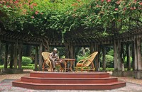 Tượng Bác Hồ ngồi làm việc trong vườn hoa tại Phủ Chủ tịch. (Nguồn: ditichhochiminhphuchutich.gov.vn)