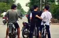 Hình ảnh ghi lại cảnh 2 học sinh đi xe đạp bị nhóm thanh niên chặn lại, lục đồ. Ảnh cắt từ clip