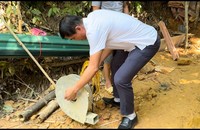 Ông Lù Văn Chánh, Phó Chủ tịch UBND xã Mường Tè bên cạnh chiếc máy thổi khí vừa được công an viên được lấy ra từ "hầm vàng".