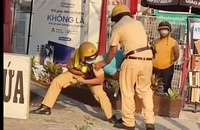 Tài xế taxi công nghệ có hành vi giật biên bản vi phạm hành chính nên bị CSGT khống chế để lấy lại (Ảnh: cắt từ video)