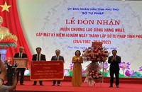 Phó Bí thư Tỉnh ủy, Chủ tịch UBND tỉnh, ông Bùi Văn Quang trao Huân chương Lao động hạng Nhất và tặng hoa chúc mừng Sở Tư pháp (đứng đầu tiên từ phải qua trái)