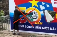 Ảnh chụp màn hình video người dân ghi lại vụ việc một người phụ nữ rạch phá banner chào mừng kỷ niệm 50 năm Ngày Giải phóng miền Nam.