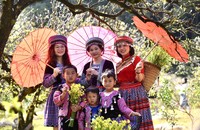 Du khách chụp ảnh cùng các em nhỏ vùng cao trong trang phục thổ cẩm của người đồng bào dân tộc (Ảnh: Lê Hanh)
