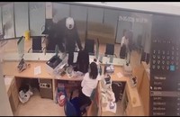 Sau khi đe dọa nhân viên ngân hàng, tên cướp trèo qua vách ngăn tiến sâu vào trong quầy giao dịch (Ảnh cắt từ clip)