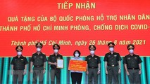 Bà Tô Thị Bích Châu, Chủ tịch Ủy ban Mặt trận Tổ quốc Việt Nam Thành phố Hồ Chí Minh tiếp nhận bảng tượng trưng quà tặng của Bộ Quốc phòng từ Trung tướng Ngô Minh Tiến. (Ảnh: TTXVN phát)