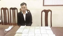 Đối tượng Vàng A Lồng, sinh năm 1989, trú tại bản Buổi Hương, xã Mường Nhà, huyện Điện Biên, tỉnh Điện Biên cầm đầu cùng vật chứng là 20 bánh heroin tại cơ quan điều tra. (Ảnh: Doãn Tấn/TTXVN)