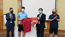 Đội trưởng Quế Ngọc Hải đại diện các cầu thủ đội tuyển tặng áo thi đấu, cờ lưu niệm cho Đại sứ Nguyễn Mạnh Tuấn.