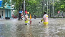 100 cảnh sát đội mưa lội nước giúp người dân Hải Phòng vượt đường ngập lụt