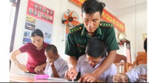 Thầy giáo Chính và cô giáo Ly cầm tay dạy các em từng chữ một. Ảnh: Hồng Anh