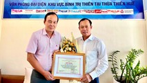 Ông Văn Đức Thọ - Phó Giám đốc NHCSXH tỉnh Thừa Thiên Huế - trao tặng giấy khen của Chủ tịch HĐQT NHCSXH cho nhà báo Nguyễn Quang Tám.
