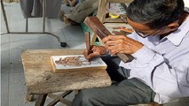 Nghệ nhân Kỳ Hữu Phước đang say sưa khắc bản gỗ, đảm bảo số lượng sản phẩm phục vụ Tết Nguyên đán cho bà con, du khách gần xa.