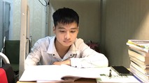 Trong lúc chờ bố nấu cơm, Minh tranh thủ ngồi ôn bài cũ.
