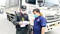 Lực lượng chức năng kiểm tra y tế đối với một trường hợp xe vận chuyển hàng hóa tại Chốt kiểm soát dịch trên quốc lộ 1, đoạn qua cầu Đồng Nai (TP Biên Hòa). Ảnh: T.Hải/Báo Đồng Nai