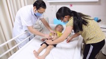 BS Nguyễn Đức Lân kiểm tra lại vết mổ cho trẻ trước khi xuất viện.