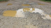 Mặt Tỉnh lộ 233 đoạn gần cổng UBND xã Hòa Bình huyện Văn Quan xuống cấp nghiêm trọng.