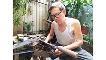 Nghệ nhân Phạm Quang Xuân với công đoạn xẻ quai dép.