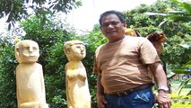 NNƯT Ksor Hnao bên những bức tượng nhà mồ do ông sáng tạo ra.