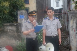 Chấp hành viên của Cục Thi hành án dân sự tỉnh Hải Dương công bố quyết định cưỡng chế thi hành án đối với vợ chồng ông Trần Văn Đ. và bà Đào Thị H.