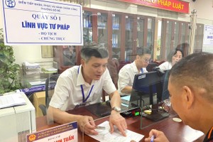 Cán bộ phường Bồ Đề, TP Hà Nội hướng dẫn người dân thực hiện các thủ tục hành chính. 