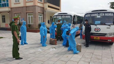 Công nhân mặc đồ bảo hộ trước khi lên xe về địa phương.
