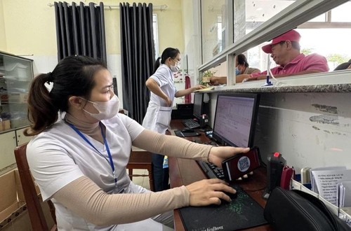 Nhân viên y tế quét mã lấy số và đăng ký khám bệnh tại các ki-ốt phát số tự động. (Ảnh: Đinh Hương/TTXVN) 