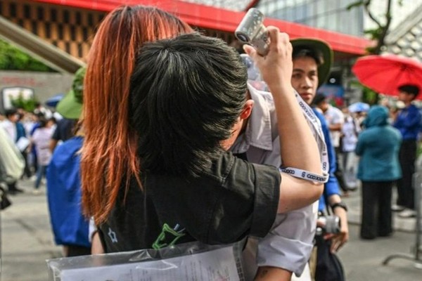 Một thí sinh nam bật khóc sau khi kết thúc môn Toán khi nhìn thấy người thân đứng chờ. (Ảnh Dân trí)
