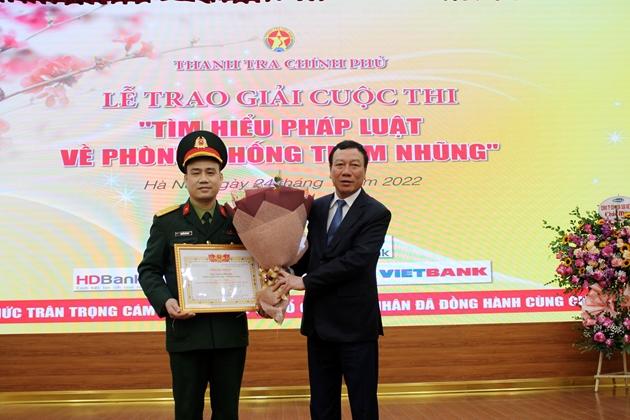 Tổng Thanh tra Chính phủ Đoàn Hồng Phong trao chứng nhận và tặng hoa chúc mừng ông Nguyễn Hữu Quý, Trường Sĩ quan Lục quân I. Ảnh: LP