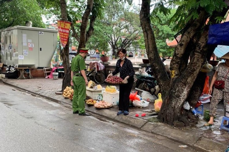 Lực lượng chức năng kiểm tra, nhắc nhở trường hợp lấn chiếm vỉa hè làm nơi kinh doanh sai quy định trên phố Dịch Vọng.