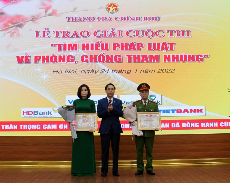 Phó Tổng Thanh tra Chính phủ, Trưởng Ban Tổ chức Trần Ngọc Liêm trao giải Nhì cho các ông, bà: Dương Thị Mai, Thanh tra tỉnh Hoà Bình; Trần Nhật Quang, Đội Điều tra tổng hợp, Công an quận Bắc Từ Liêm, Hà Nội. Ảnh: LP