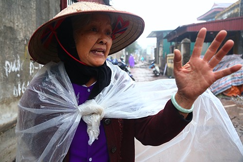 Bà Chín đội mưa cùng con cháu nhặt đạn. Ảnh: Phạm Dự.