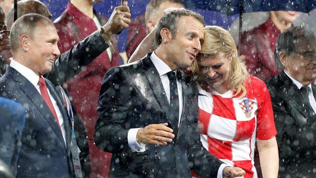 Ông Macron và bà Grabar-Kitarovic đội mưa sau trận chung kết. Ảnh: AFP.