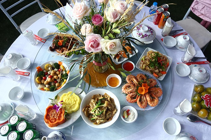 Thực đơn tiệc trưa ngày 9/2 của cặp 9X gồm: súp gà, gà hấp lá chanh, chim bồ câu quay, cá tầm chiên, bò xào, chả quế, ốc hấp xả lá chanh, nem hải sản, nộm chân gà rút xương, xôi uyên ương, canh măng móng giò, canh mọc thập cẩm, rau mầm đá luộc chấm trứng xì dầu, canh chua nấm mọc, cơm tám, bia rượu, nước ngọt, hoa quả tráng miệng.