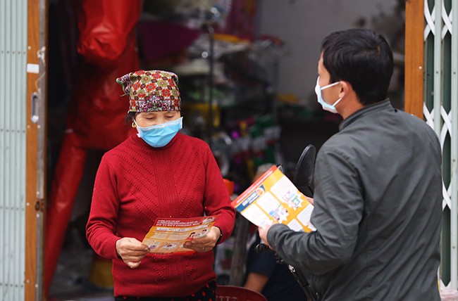 Cán bộ xã Sơn Lôi (Bình Xuyên, Vĩnh Phúc) phát tờ rơi phòng chống viêm đường hô hấp cấp do covid-19 cho người dân. Ảnh: Tất Định