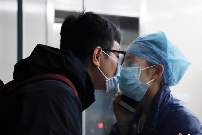 Y tá Chen Ying và bạn trai Huang Qianrui hôn nhau qua tấm kính cách ly ở bệnh viện Đại học Y Khoa tỉnh Chiết Giang. Ảnh: CNNews.