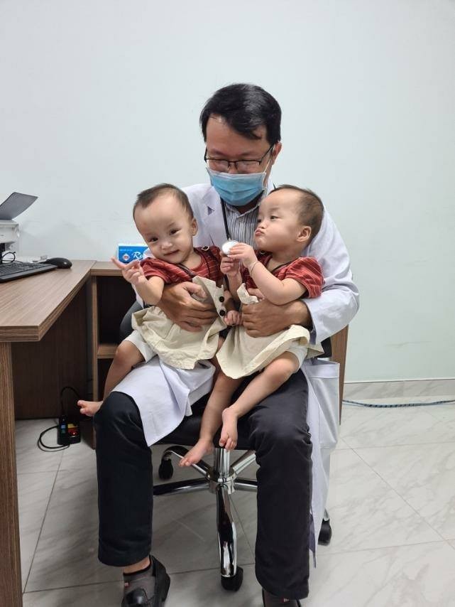 Trúc Nhi - Diệu Nhi vui mừng khi được bác sĩ bế bồng. Ảnh bệnh viện Nhi đồng Thành phố.