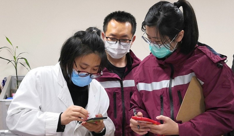 The virus hunters work on another case as Gong (right) and a colleague check their findings. Photo: Shanghai CDC