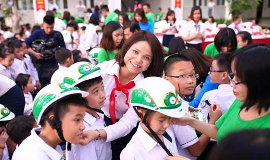 Bà Đỗ Thị Mai Hiệu trưởng trường tiểu học Dịch Vọng B - đội mũ bảo hiểm cho học sinh trong buổi lễ.
