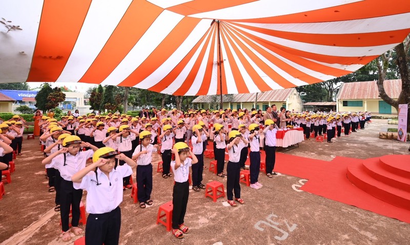 Các em nhỏ tập đội mũ bảo hiểm.