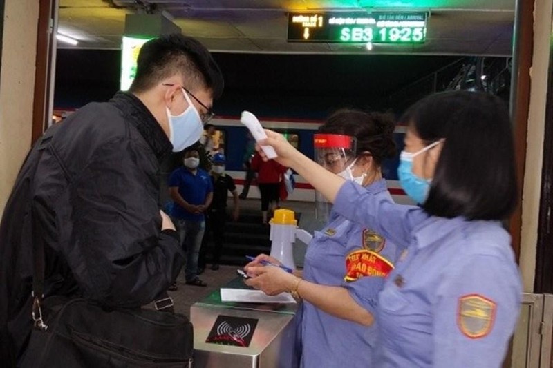 Kiểm tra thân nhiệt và thực hiện khai báo y tế cho hành khách đi tàu.
