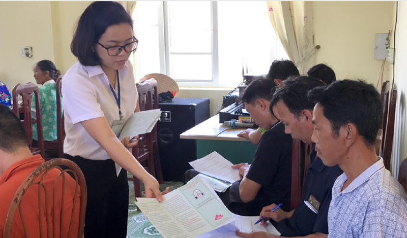 chuyên viên trợ giúp pháp lý - Trung tâm Trợ giúp pháp lý (Sở tư pháp Quảng Ninh) phát tờ rơi tuyên truyền pháp luật cho người dân