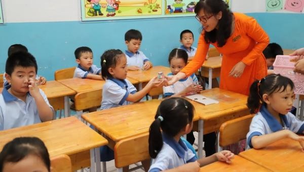 Giáo viên tạo tâm lý cho học sinh những ngày đầu trở lại trường. Ảnh Tuổi trẻ.