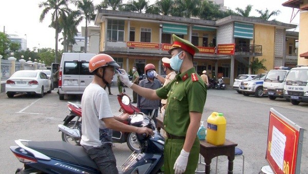 Kiểm tra thân nhiệt cho người dân khi đến làm việc tại cơ quan Công an TP Huế.