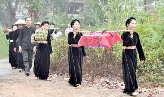 Những người phụ nữ cùng chồng mang cỗ về biếu nhà ngoại trong ngày tết Vu lan.