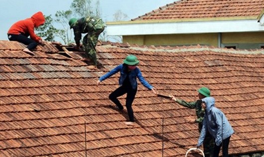 Cán bộ, chiến sĩ giúp dân sửa lại nhà tốc mái sau bão.